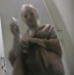 An articulated hidden camera is set up in a public bathroom right inside of the toilet on the floor. This is most likely Russian or Eastern European.